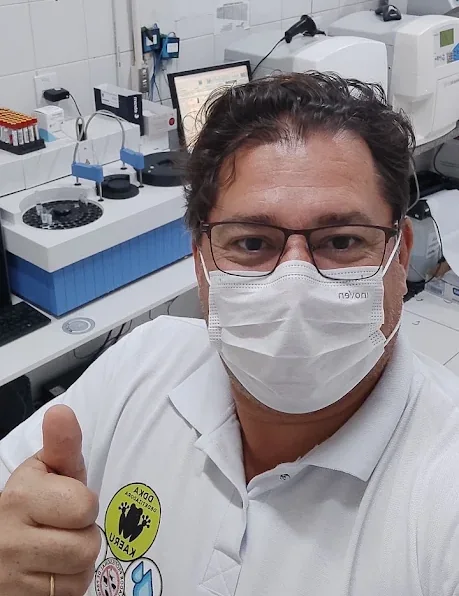 Ivo Enoc, fundador da DDKA, de máscara e camisa da empresa, em atendimento num laboratório